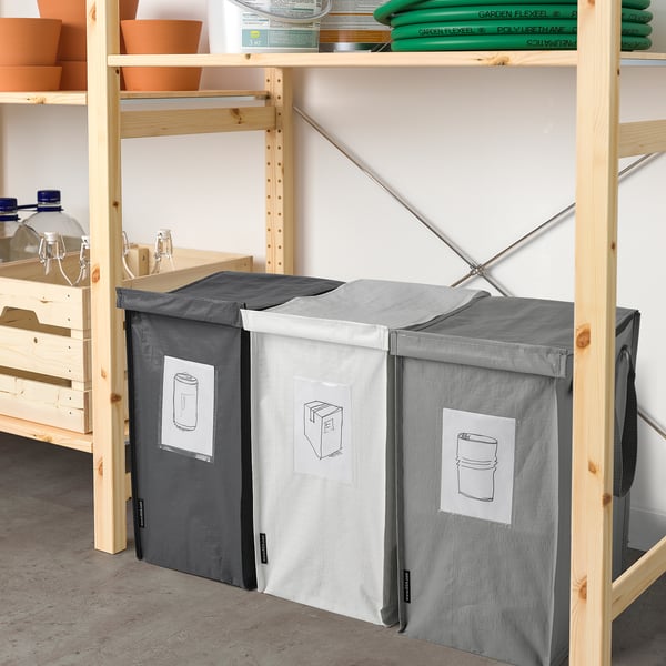 Three large grey DIMPA recycling bags on shelves, each with a handle and labelled pocket, neatly organised.