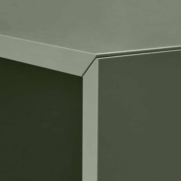 Close-up of modern furniture with sleek green surface and chrome edge.