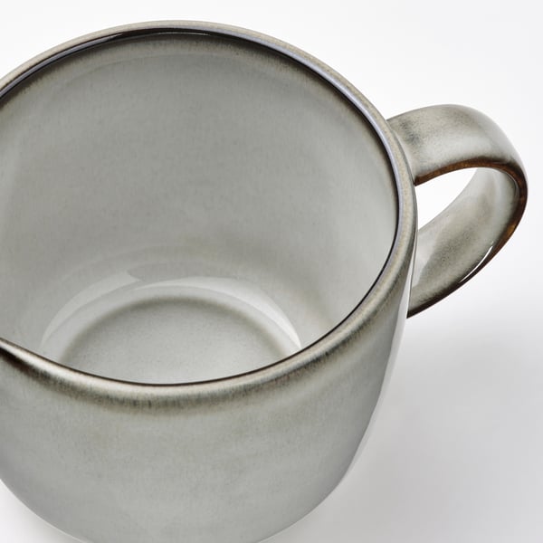 Sleek, stoneware jug with speckled grey glaze, sturdy handle for comfortable grip.