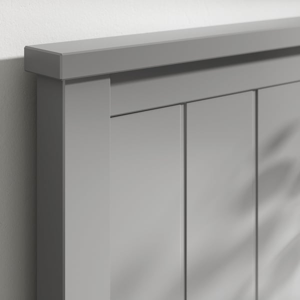 Close-up of a modern bed frames corner, showcasing sleek grey tones, sharp edges, and smooth surfaces.