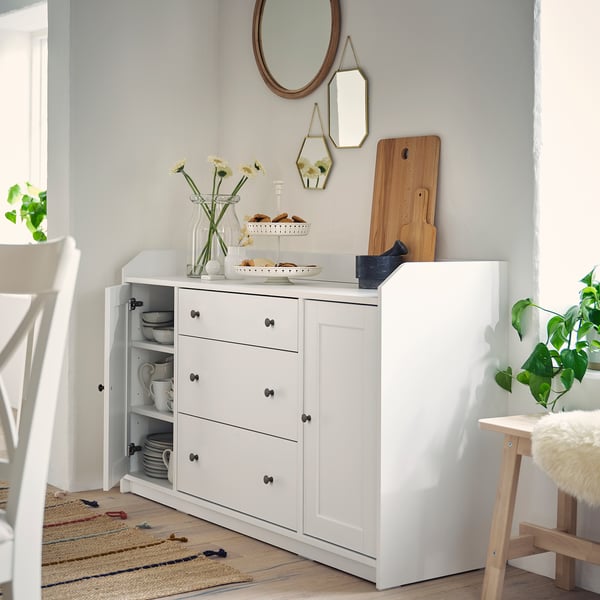 HAUGA sideboard with open/closed storage, black handles, and top shelf with mirror and decorations.