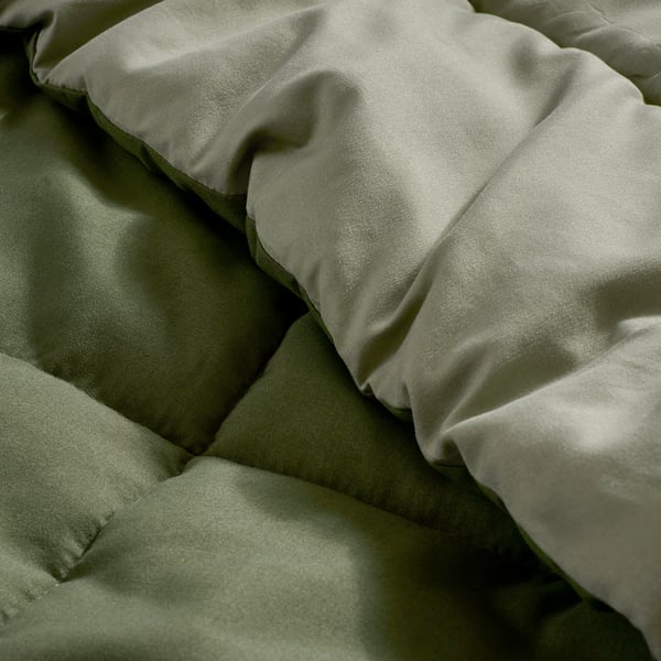 Soft, textured green bedding set with smooth, inviting fabric, showcasing quality and comfort.