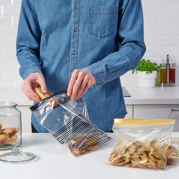 Person sealing ISTAD snack bag on counter.