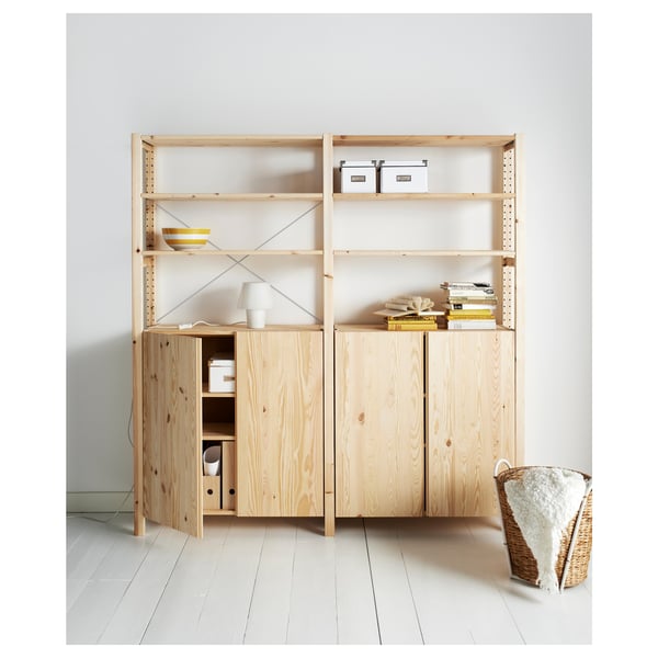 Light wooden IVAR bookcase with shelves and storage compartments. Holds books, boxes, and lamps.