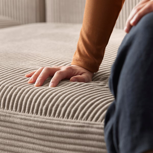 Hand touching beige JÄTTEBO sofa