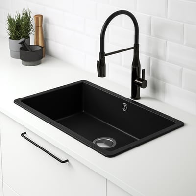 Black KILSVIKEN quartz sink with a pull-down tap, set in a white countertop against a white tiled backsplash.