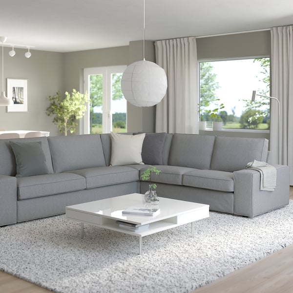 Modern living room with KIVIK sectional sofa, coffee table, large window & rug.