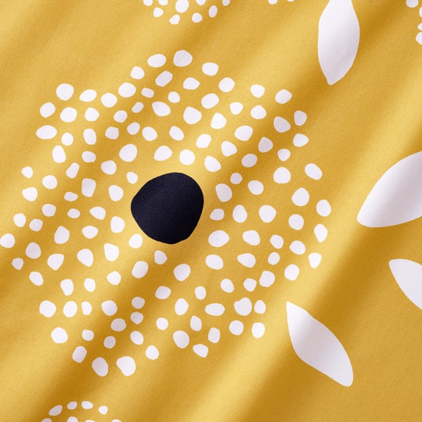 Bright yellow fabric with white dots and a dark circle, showcasing high-quality cotton texture.
