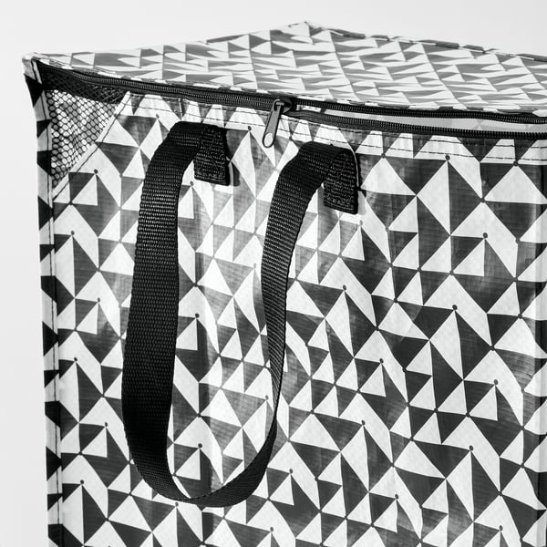 Black and white geometric-patterned reusable shopping bag with sturdy black handles and zip top, indicating durability and practicality.