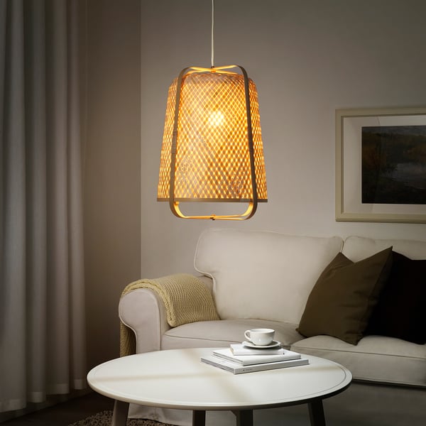 Modern living room with KNIXHULT lamp, cream armchair, and wall painting.