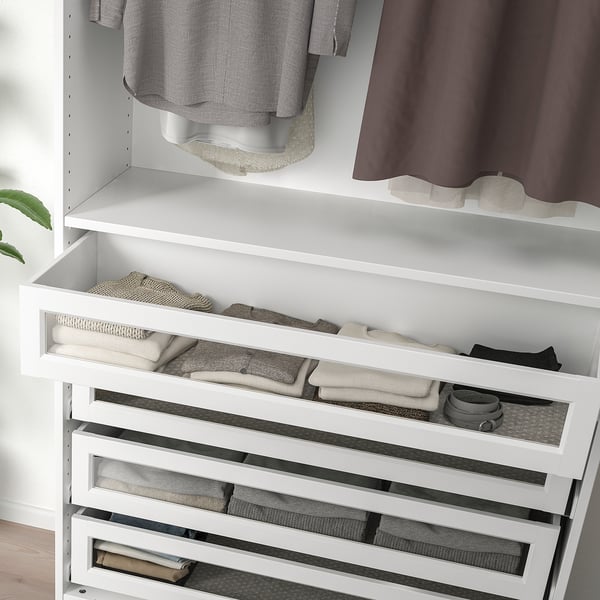 White pax wardrobe with glass drawers, neatly storing folded clothes. Soft-close drawer system visible.