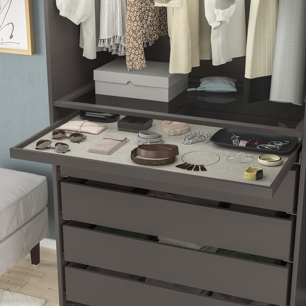Modern wardrobe with open drawer showing jewellery and accessories on grey mat.