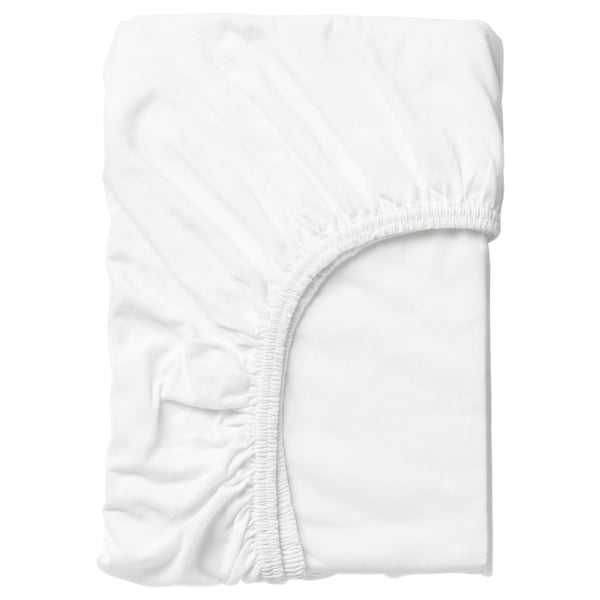 Folded white sustainable cotton sheet, elastic for secure fit.