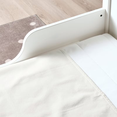 White mattress protector with waterproof backing, designed for babys safety. Fits both cribs and beds, securing under fitted sheets.