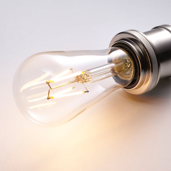 Illuminated vintage-style led bulb, clear glass, warm white light.