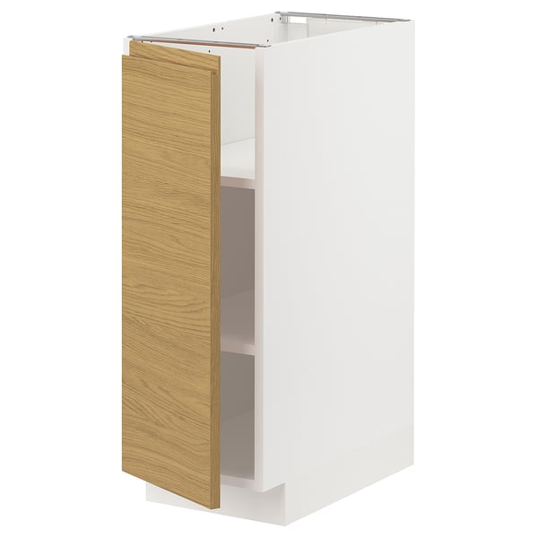 A white METOD kitchen cabinet with a light oak front and integrated handles, featuring a minimalist and warm design.