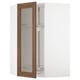 A white METOD kitchen cabinet with walnut-finished glass doors, featuring an adjustable shelf inside.