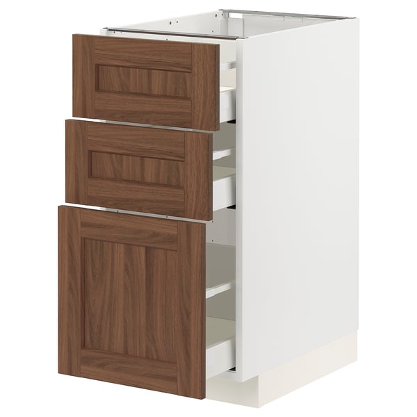 An open METOD kitchen cabinet with walnut-finished drawers. It has three drawers and a push-to-close mechanism.