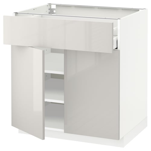 A white METOD kitchen cabinet with a high-gloss finish, featuring a single drawer and an open compartment.