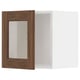 A METOD kitchen cabinet with walnut woodgrain glass doors and white interior, offering a modern and warm design.