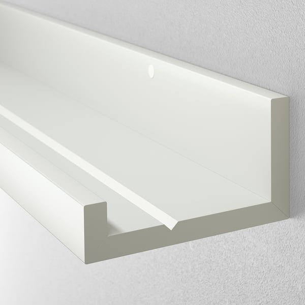 White wall shelf, clean and modern. Designed with a groove for holding picture frames. Ideal for displaying photos and artwork.