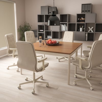 Modern office with light wood table, beige chairs, fruit bowl, and plant.