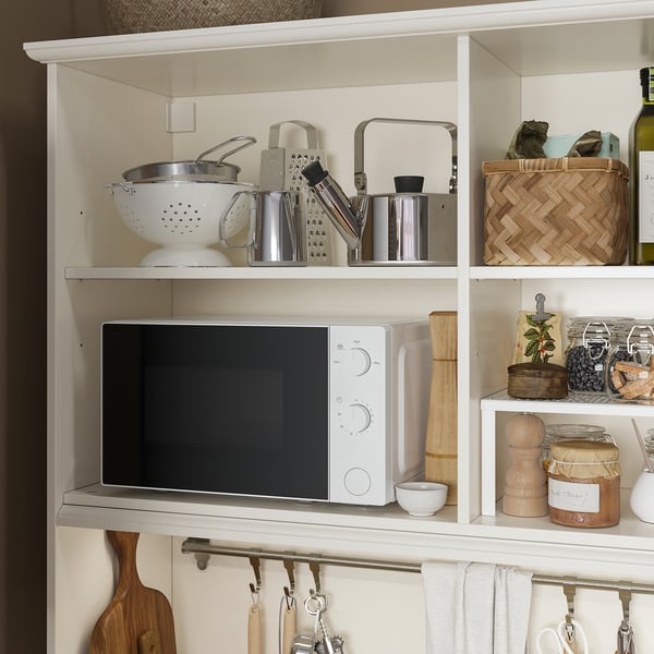 Kitchen shelves with microwave, tools, and utensils organised for easy access.
