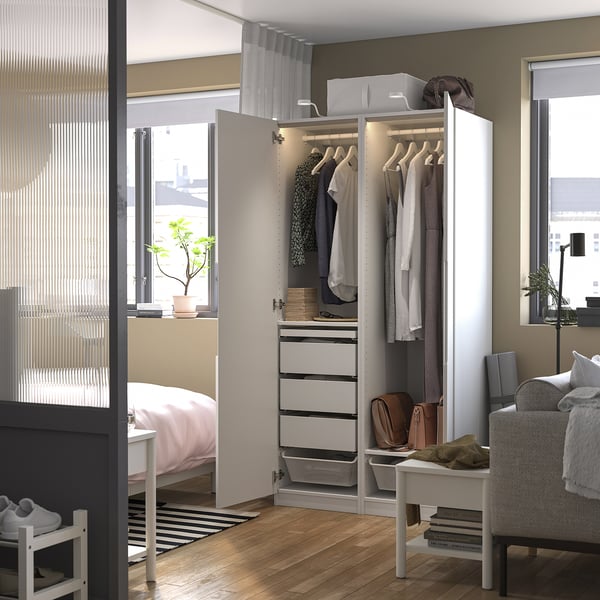 Modern wardrobe displaying clothes, drawers, and accessories. Integrated lighting illuminates organised garments and storage.