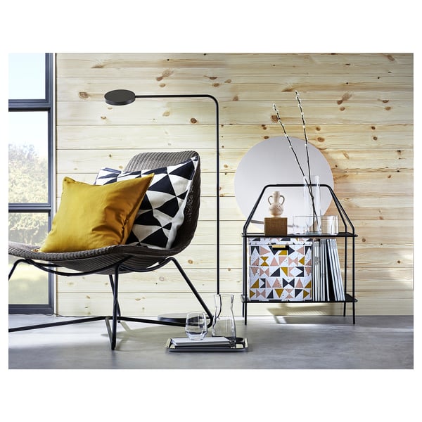 Modern living room with RÅDVIKEN chair, pillows, lamp, books, vase, wood wall, window.