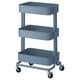 A blue ikea RÅSKOG storage trolley with three tiers and wheels for mobility. Its sturdy with a metallic finish.