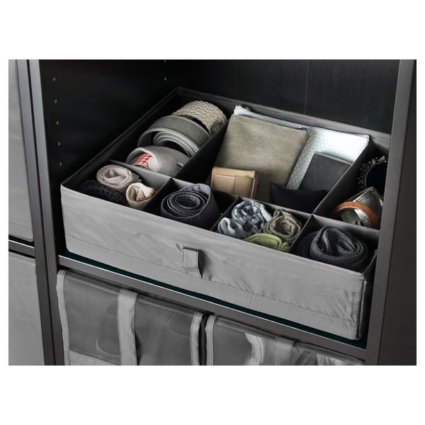 Organised drawer with three grey compartments filled with rolled socks and folded accessories, keeping items tidy and easily accessible.