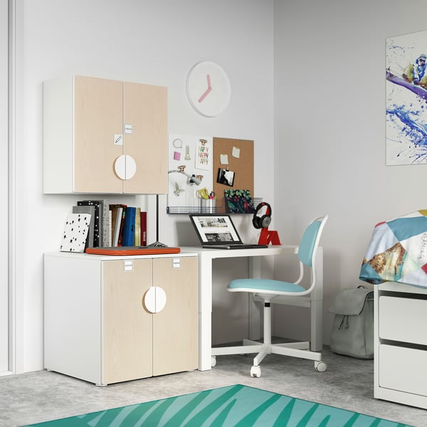 A kids room with SMÅSTAD white and light wood storage, a blue chair, a desk, and colourful decorations.