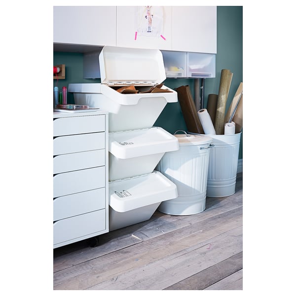 Stacked white SORTERA storage bins with foldable lids in an organised workspace.