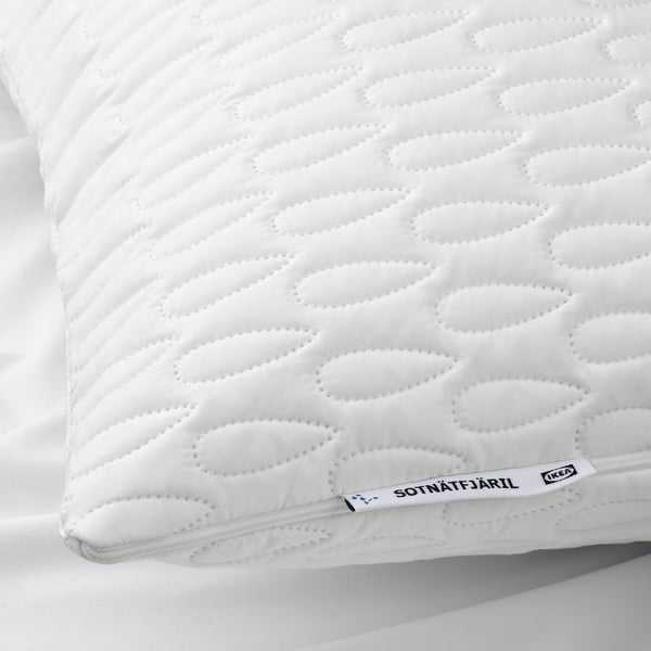 Close-up of a white, quilted pillow protector with visible stitching and a discreet label reading SOTNÄTFJÄRIL IKEA.