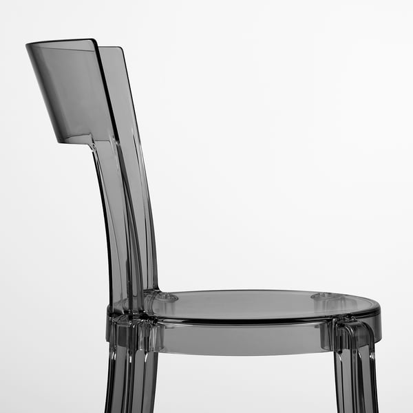 Modern, sleek chair with curved back and seat, made of transparent, durable plastic.