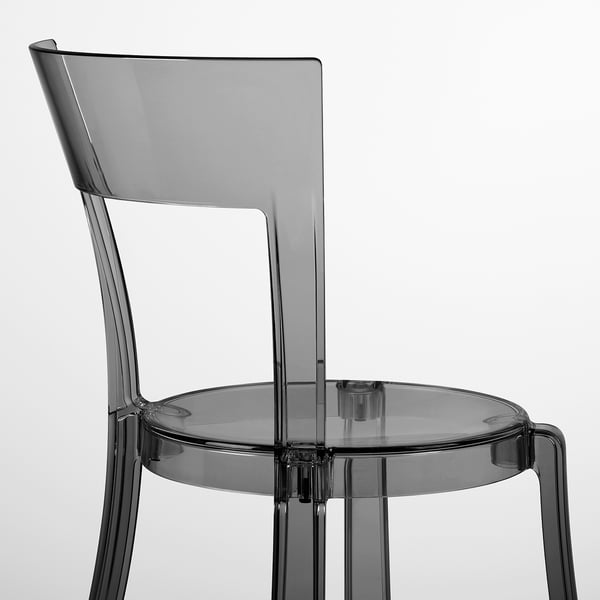 Modern, clear chair with curved back and seat, sturdy legs, elegant design.