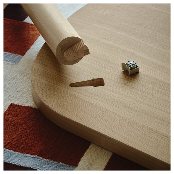 Light wooden table part with a metal fixture and peg. Simple, efficient assembly shown, suitable for indoor use.