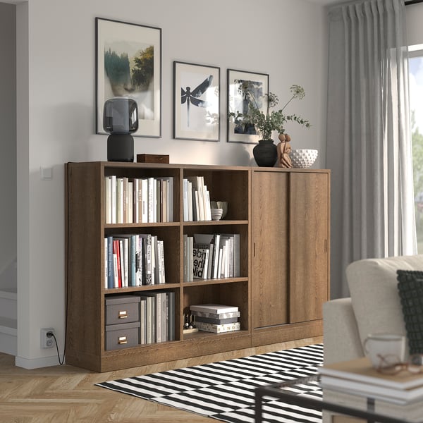 Honey oak TONSTAD bookcase, open & cabinet shelves, by window, cosy chair.