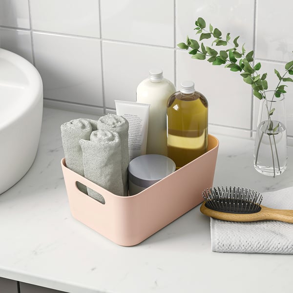 Bathroom organiser with towels, bottles, brush.