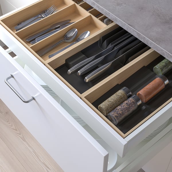 Drawer organiser with compartments for utensils and knives.
