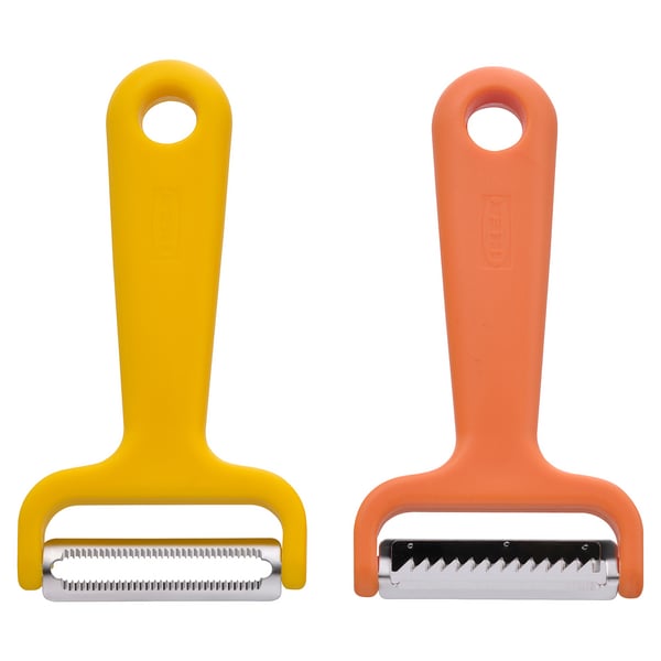 Two vibrant UPPFYLLD vegetable cutters, yellow & orange, create vegetable strips.