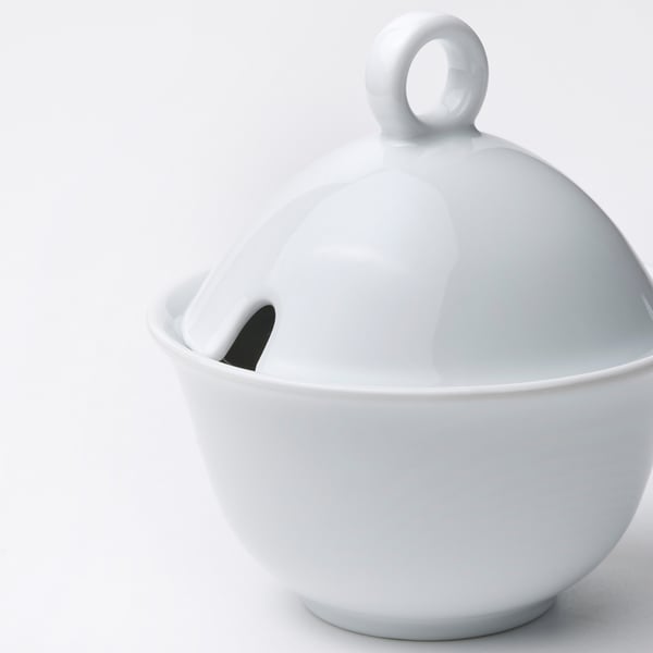 Small white porcelain sugar bowl with a lid and loop handle, simple and sturdy design.