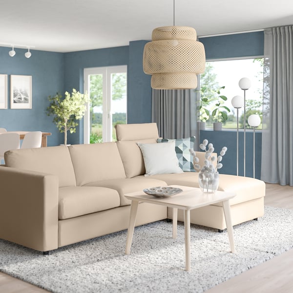 Modern living room with large beige VIMLE sectional sofa, round coffee table, layered bamboo pendant light, grey curtains, and large windows.