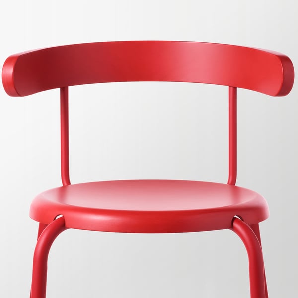 Bright red modern chair with smooth rounded back and seat, four sturdy legs, sturdy, sleek finish.
