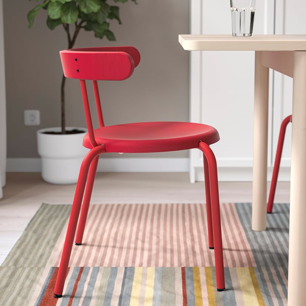 Bright red chair hangs on table, easy to clean, sturdy legs, soft back support.
