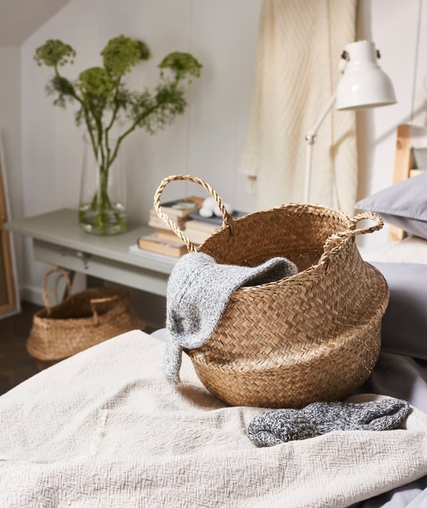 A FLÅDIS basket on a bed