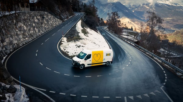 Un vehículo eléctrico de transporte de IKEA recorre una carretera de montaña en Suiza.