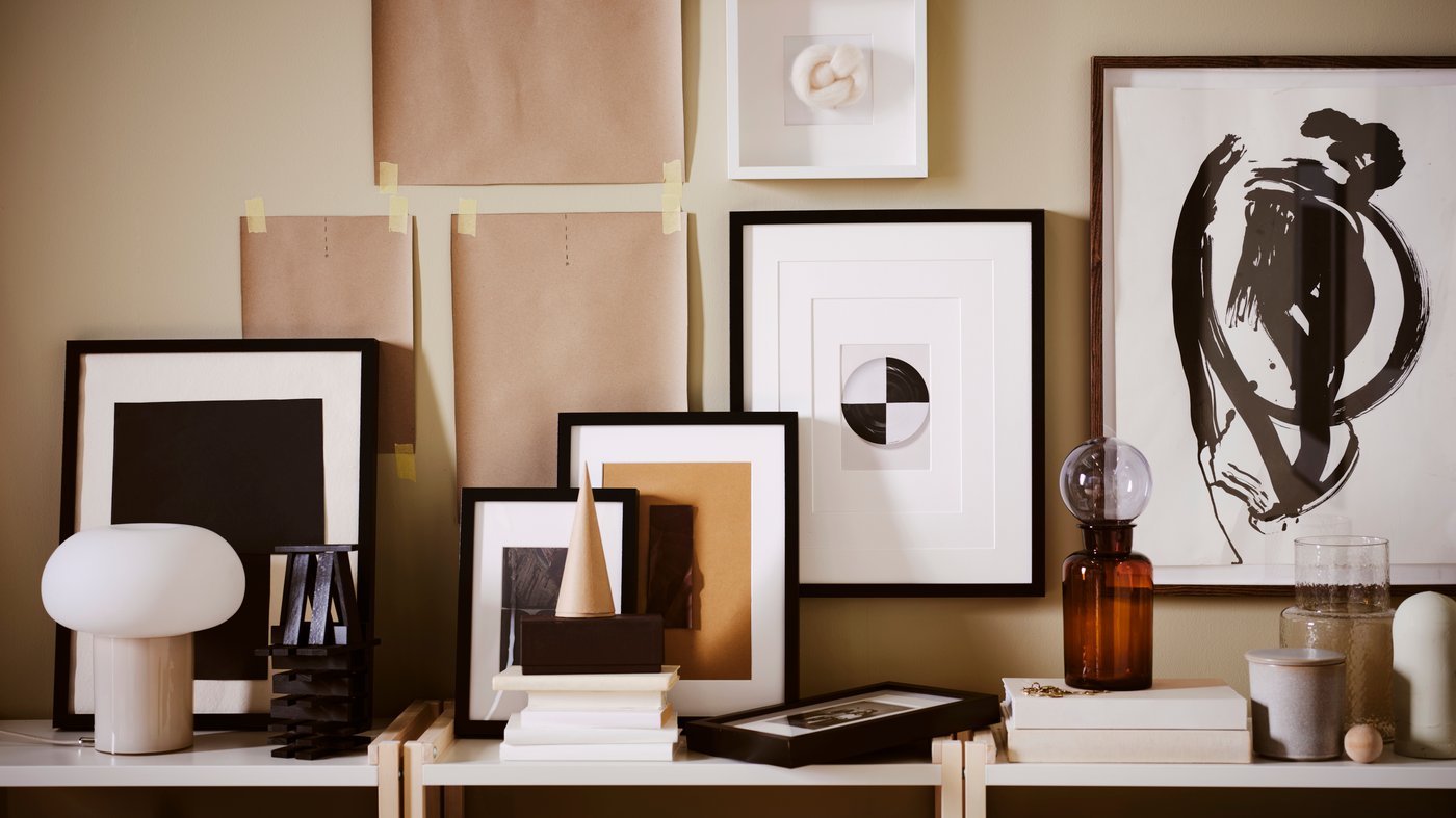 The image shows a DEJSA lamp, as well as pictures and other decorative objects framed in black frames in a Japanese interior design style.