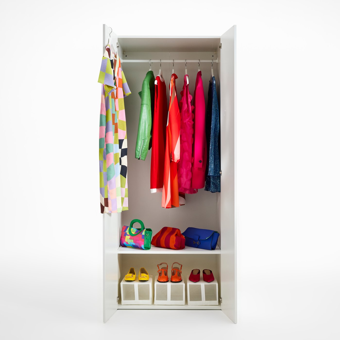 A white LASTARE wardrobe. The doors are open and inside, we see colourful vintage clothes and accessories.