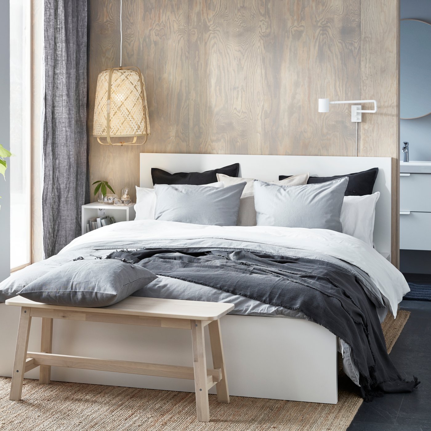White MALM bedframe in bedroom against ash stained wall next to grey curtains.